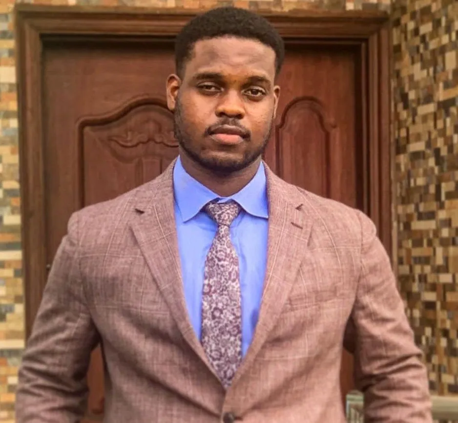 Bright Uzosike, head and shoulders, in a jacket and tie